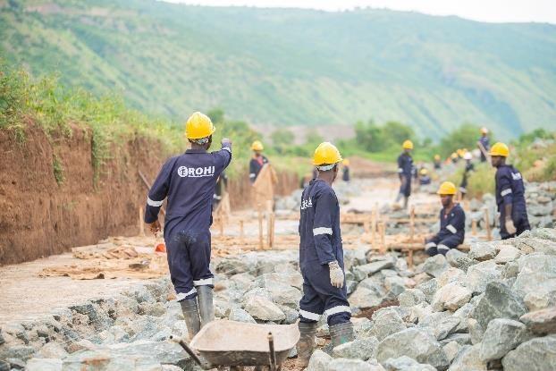 Construction personnel building a stone drainage structure